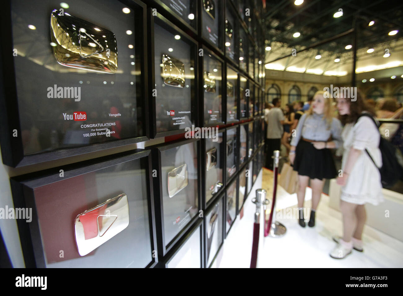 I visitatori che guardano al Wall of Fame di YouTube, che riconosce le emittenti di YouTube che hanno superato i 100,000 iscritti al Summer in the City Festival, il più grande evento della comunità YouTube del Regno Unito all'Alexandra Palace di Londra. Foto Stock