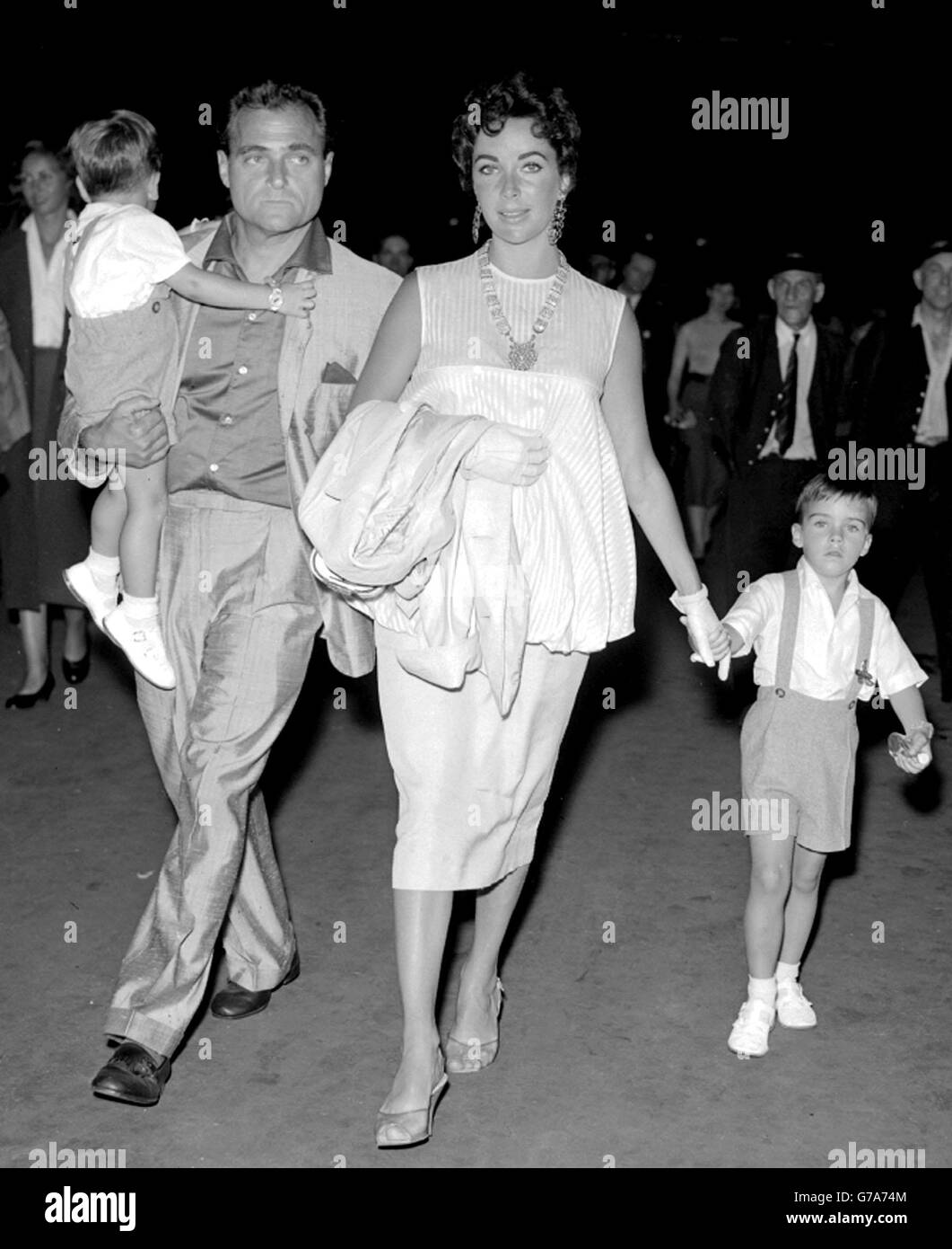 Michael Todd e sua moglie Elizabeth Taylor, dopo la prima di Londra di 'Around thew World in 80 giorni'. Michael tiene il figlio di Elisabetta Christopher (2) e il suo figlio di quattro anni Michael, tenendo la mano della madre. Foto Stock