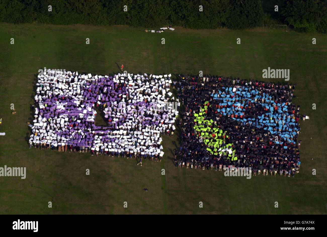 Foto aerea di centinaia di Scout che formano un mosaico umano che mette in evidenza la causa del commercio equo con i paesi più poveri. 1,800 ragazzi e ragazze e i loro leader che hanno formato l'emblema del Fair Trade al Campeggio Downe International vicino a Biggin Hill, a sud-est di Londra. Il mosaico è stato il culmine di uno speciale evento internazionale presso il sito che ha educato gli Scout da tutto il mondo sulle questioni del commercio equo e solidale. Foto Stock