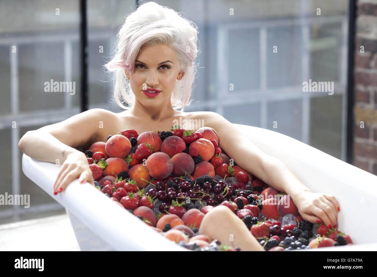 Cantante e personalità televisiva Ashley Roberts si pone in un bagno di frutta e ghiaccio per il lancio della gamma di vini bianchi e rossi baciati dal sole di Blossom Hill. Foto Stock