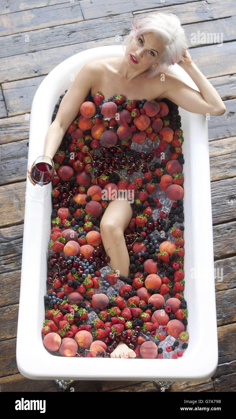 Cantante e personalità televisiva Ashley Roberts si pone in un bagno di frutta e ghiaccio per il lancio della gamma di vini bianchi e rossi baciati dal sole di Blossom Hill. Foto Stock