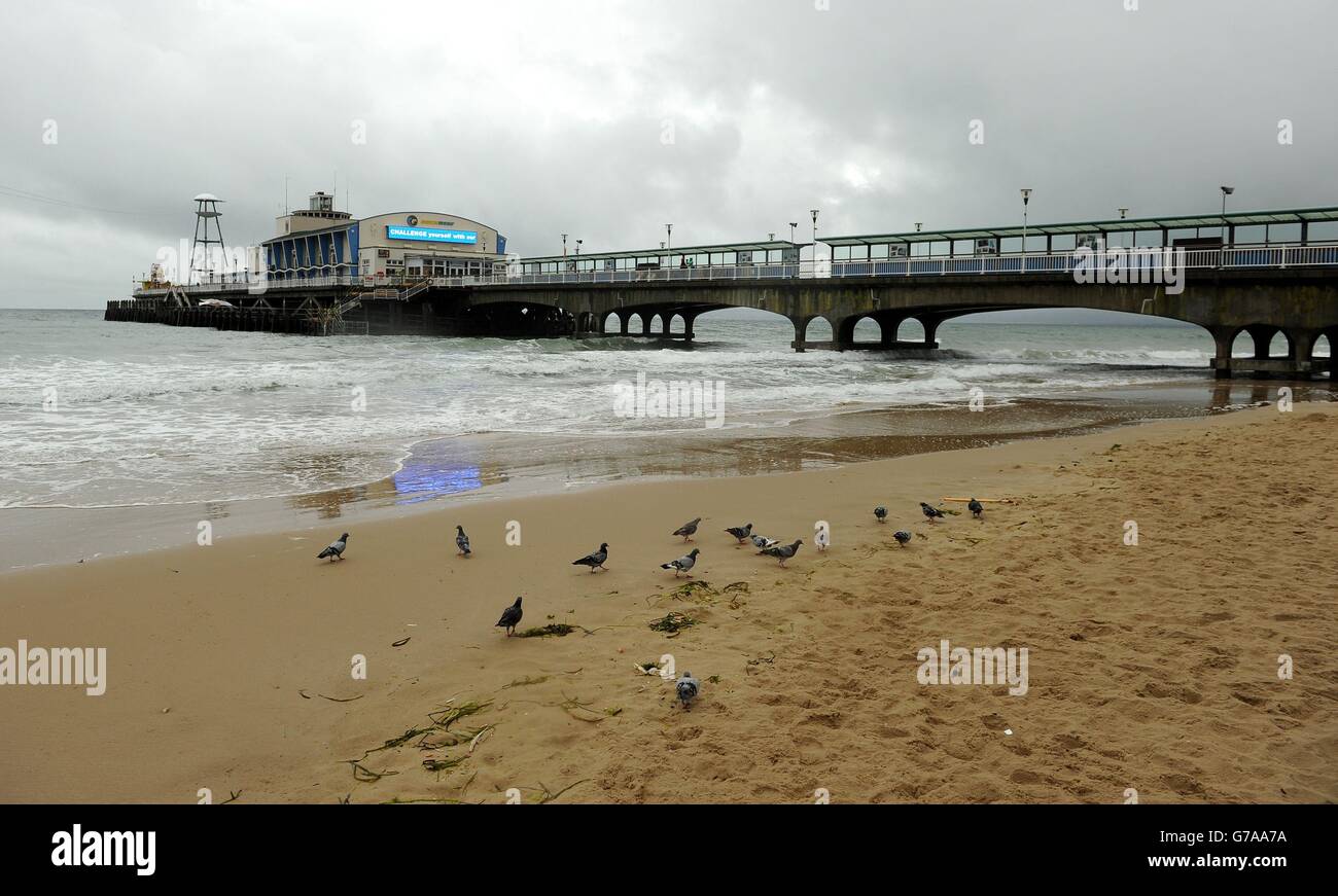 Il molo su una deserta Bournemouth Beach il lunedì delle feste della Banca quando arrivano vento e pioggia. Foto Stock