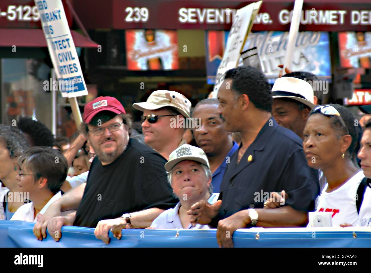 Il regista Michael Moore, attivista Leslie Cagan e don Jesse Jackson per una protesta che ha attirato decine di migliaia di persone sulle strade di New York alla vigilia della Convention Nazionale Repubblicana. Foto Stock