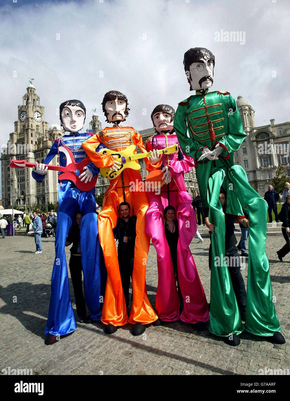 I burattini dei Beatles, alti 12 metri, passano davanti al Liver Building di Liverpool durante il Mathew Street Festival del 2004. Gli organizzatori affermano che si tratta del più grande festival di musica del centro cittadino gratuito d'Europa. Foto Stock