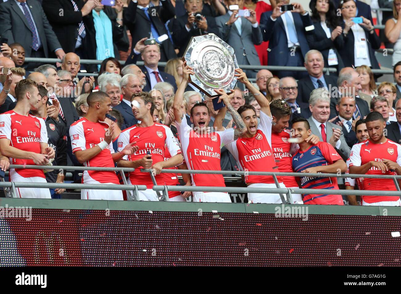 Mathieu Debuchy (al centro) e Mathieu Flamini (al centro a destra) alzano il trofeo sul balcone dopo la vittoria sulla città di Manchester nella partita Community Shield al Wembley Stadium di Londra. Foto Stock