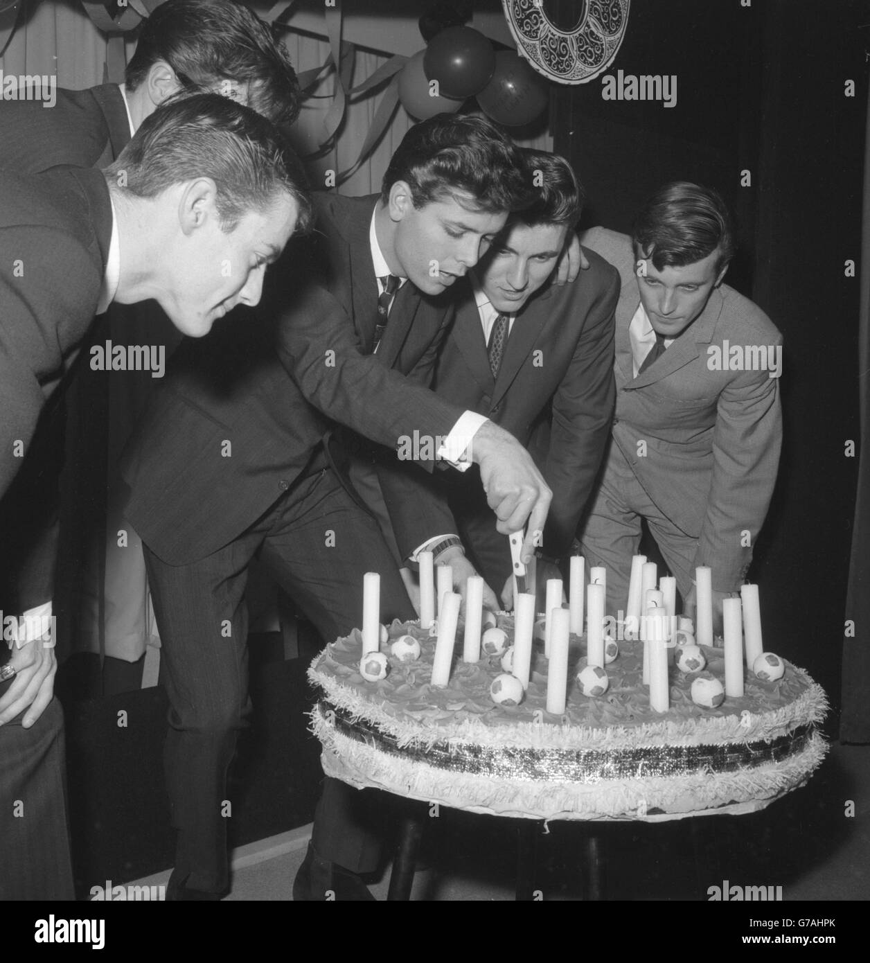 Il cantante Cliff Richard (3° da sinistra) ha il suo gruppo musicale, The Shadows, in stretta presenza mentre taglia la torta al suo ventunesimo compleanno a Londra. Foto Stock