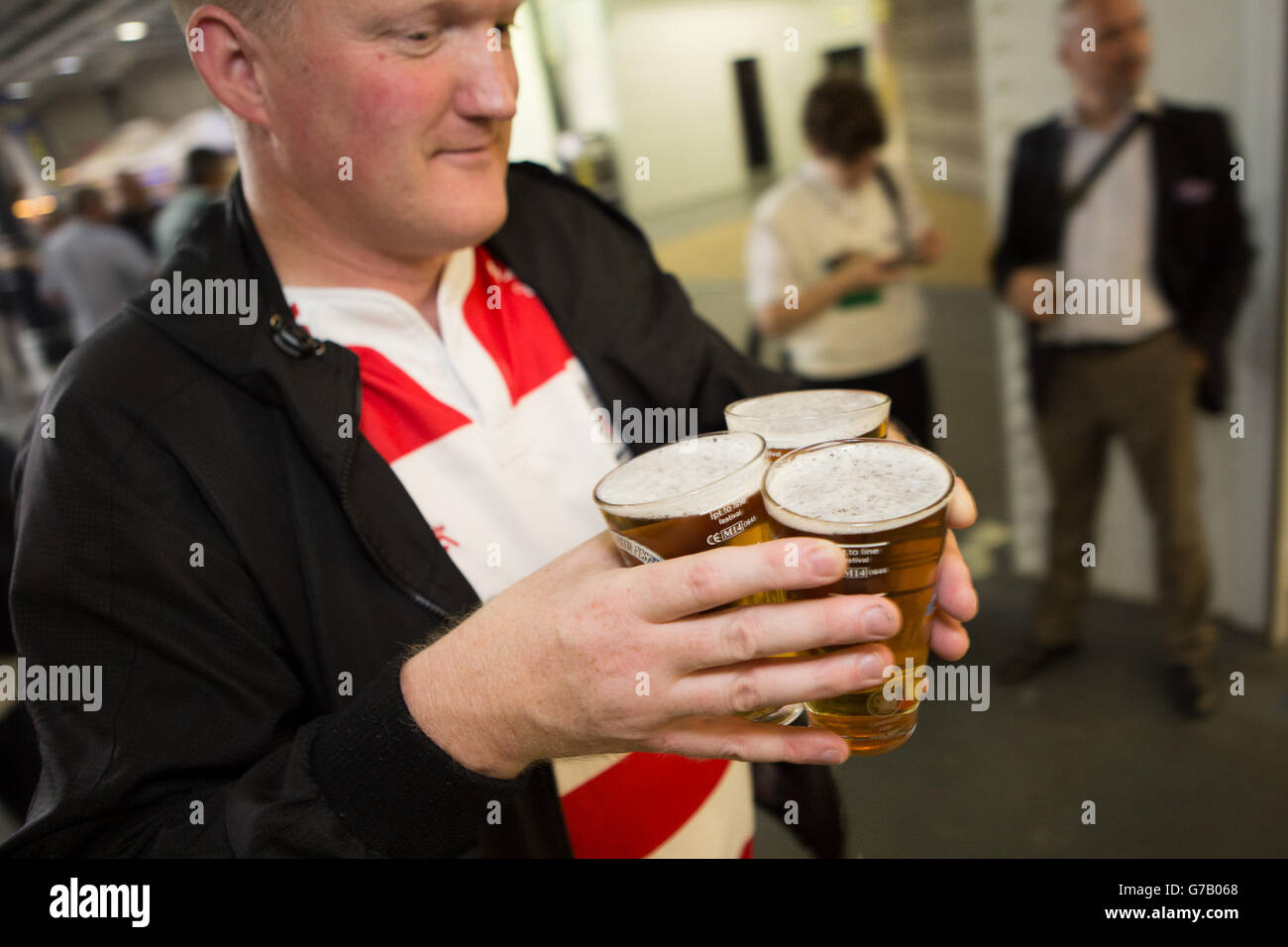 Un uomo che tiene tre pinte di birra al Great British Beer Festival (GBBF) di Olympia London, Keningston, Londra, organizzato dalla Campaign for Real Ale (CAMRA). Foto Stock