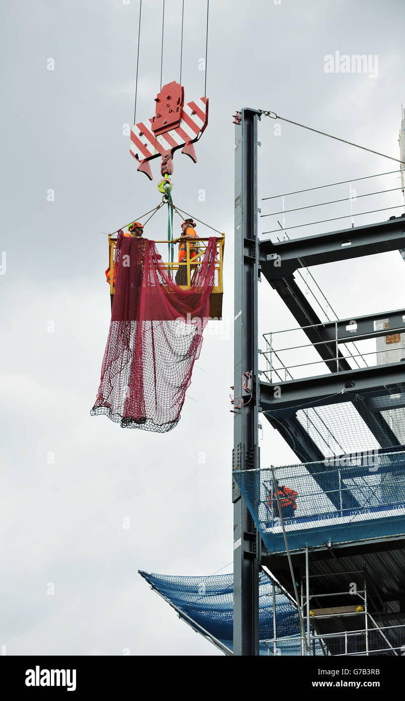 Foto di magazzino dei lavoratori edili in una culla di sicurezza di montaggio rete presso il cantiere dei nuovi uffici di Bloomberg situato tra le stazioni Mansion House e Cannon Street nella città di Londra. Foto Stock