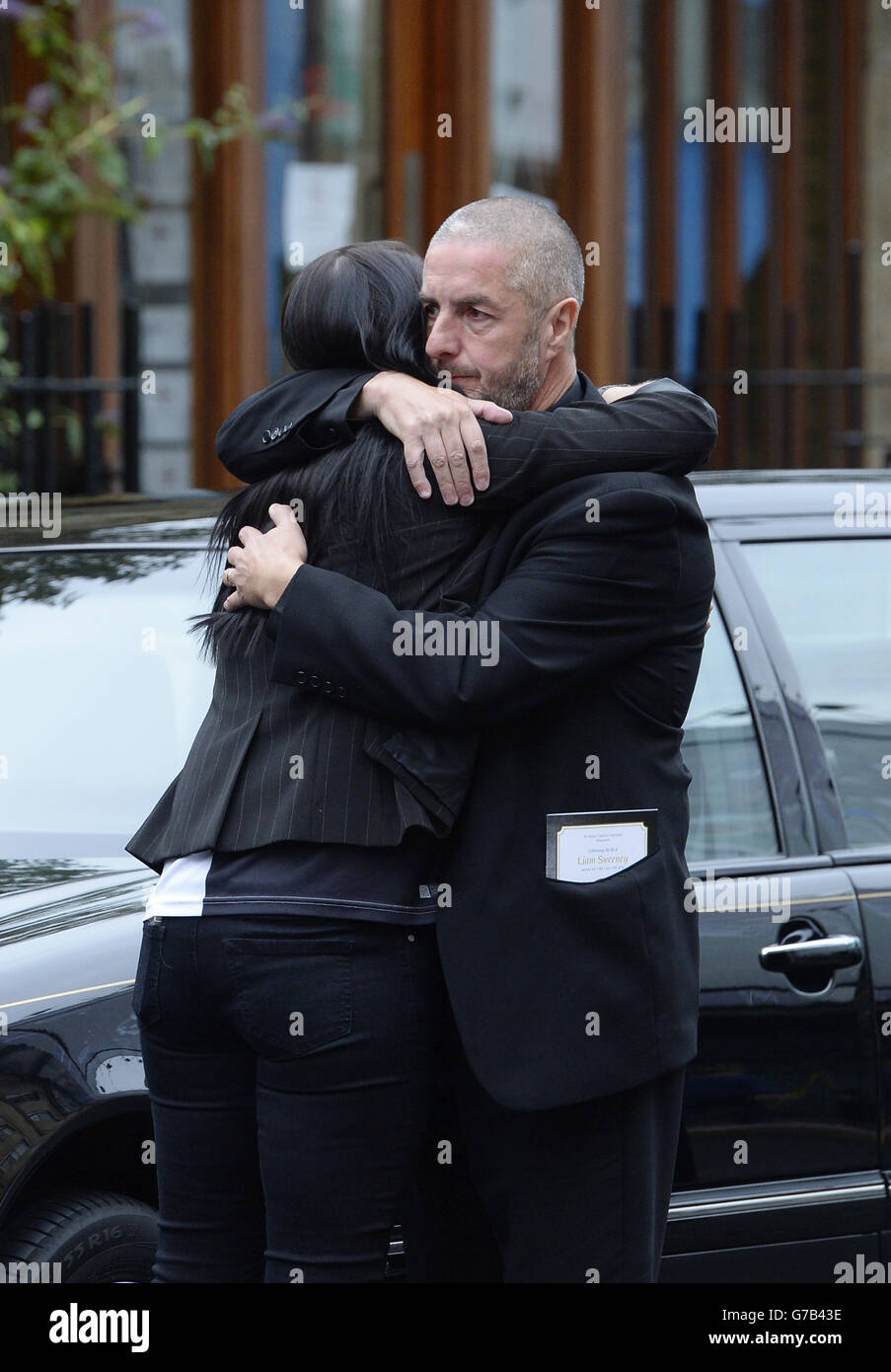 Barry Sweeney è abbracciato fuori della Cattedrale di St Mary, Newcastle, dove ha avuto luogo il funerale di suo figlio e della vittima del volo MH17 Liam Sweeney. Foto Stock