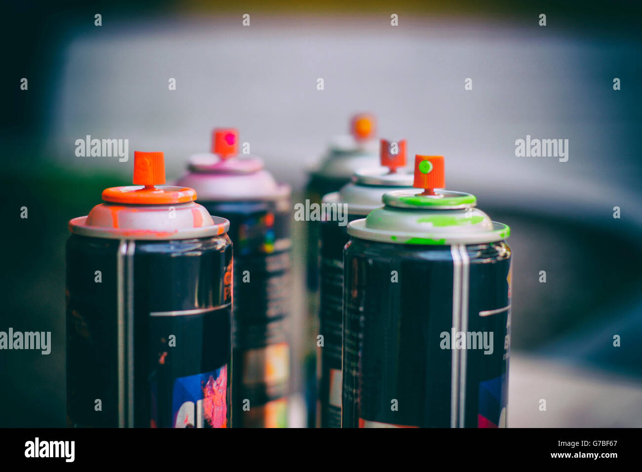 Fotografia di alcune bombolette di vernice spray e uno sfondo sfocato Foto Stock