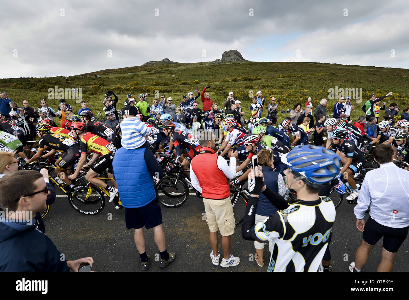 Le folle si acclamano sul peloton mentre guardano sotto Hay Tor durante una salita su Dartmoor, Devon, durante la quinta tappa del Tour of Britain del 2014. Foto Stock