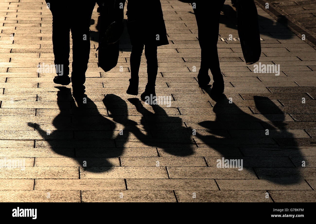 Le ombre sono gettate dalle persone che camminano in Princes Street a Edimburgo, mentre il sole tramonta questa sera. Foto Stock