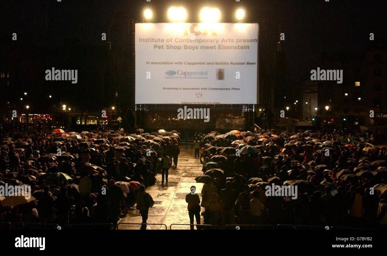 La folla attende sotto la pioggia prima che i PET Shop Boys eseguano un nuovo punteggio per il classico film del 1925 "Battleship Potemkin" con la famosa Dresden Sinfoniker a Trafalgar Sqaure, nel centro di Londra. L'evento è il momento culminante del programma estivo di Trafalgar Square, con oltre 10,000 persone attese. Foto Stock