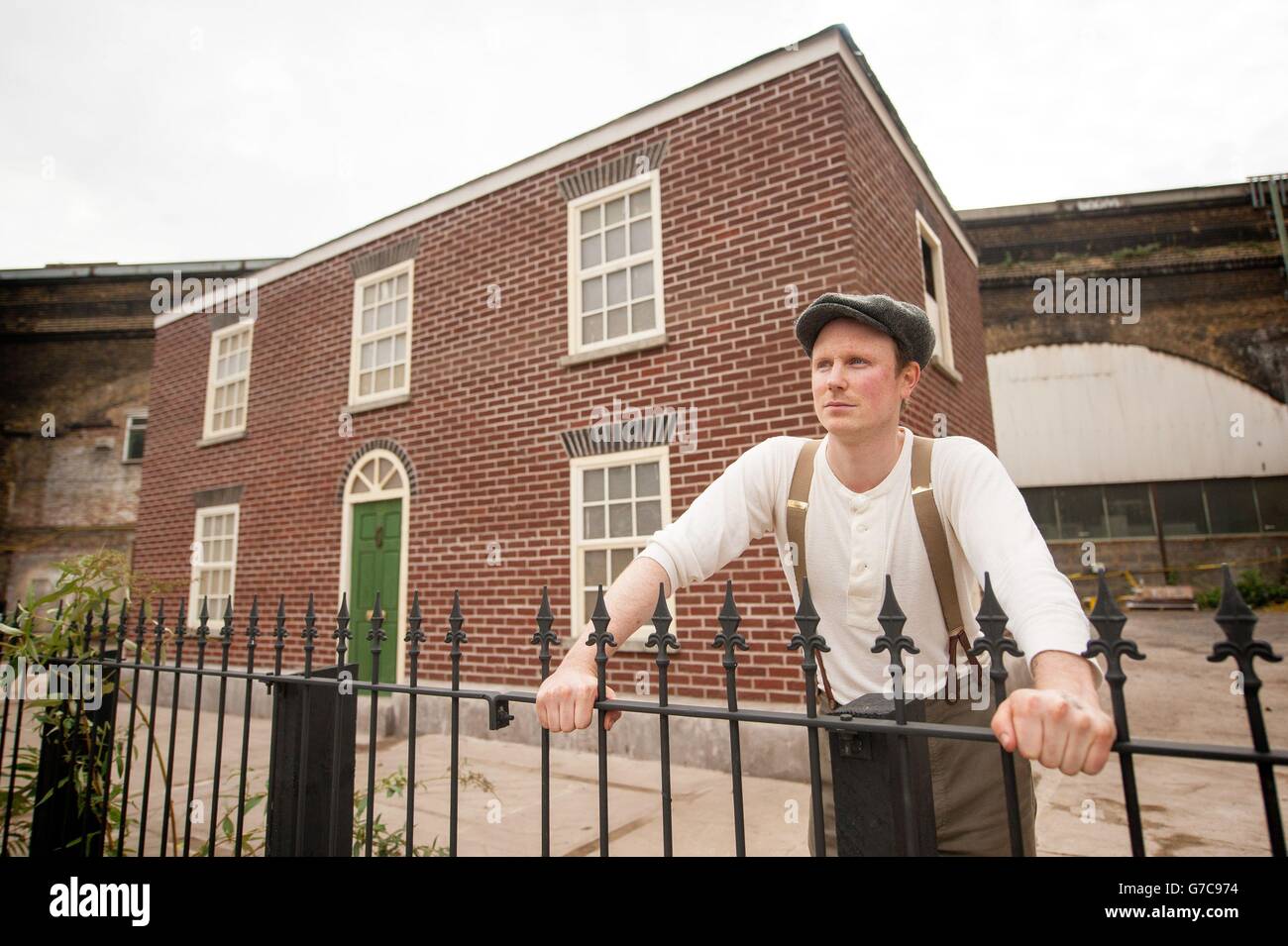 L'artista Alex Chinneck con il suo lavoro 'A Pound of Flesh for 50p', una casa a due piani composta da 8,000 mattoni di cera su Southwark Street, nel centro di Londra, che si fondono a terra per 30 giorni. Foto Stock