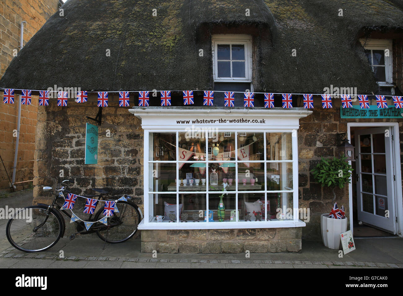 Negozi decorati con conigliatura mentre il Tour of Britain passa attraverso Broadway nel Worcestershire durante la quarta tappa del Tour of Britain del 2014. Foto Stock