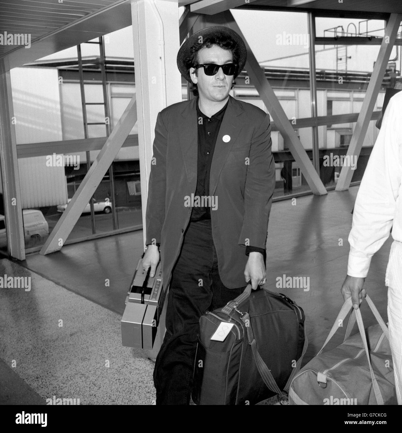 Il cantante britannico Elvis Costello arriva all'aeroporto di Heathrow da Los Angeles. Foto Stock