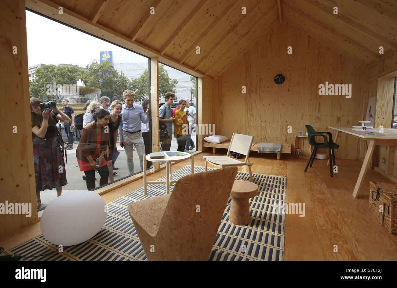 La gente guarda una stanza del designer Jasper Morrison basata su una casa di un fantino come parte del progetto 'A place chiamed Home' in Trafalgar Square nel centro di Londra, dove i designer hanno creato la propria visione di una stanza come parte del London Design Festival 2014. Foto Stock