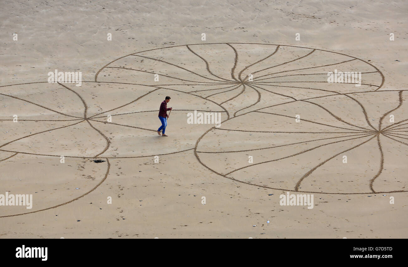 L'artista di sabbia Ross Andrews al lavoro su un pezzo dal titolo 'Legacy No.II' sulla spiaggia di Ramsgate a Kent, Andrews che è cresciuto a Kent, usa la costa di Thanet come sua tela per le opere d'arte prodotte in circa quattro ore in una corsa contro le maree, utilizza un rastrello e un bastone per creare i suoi disegni freestyle, che dice di non pianificare prima di iniziare. Foto Stock