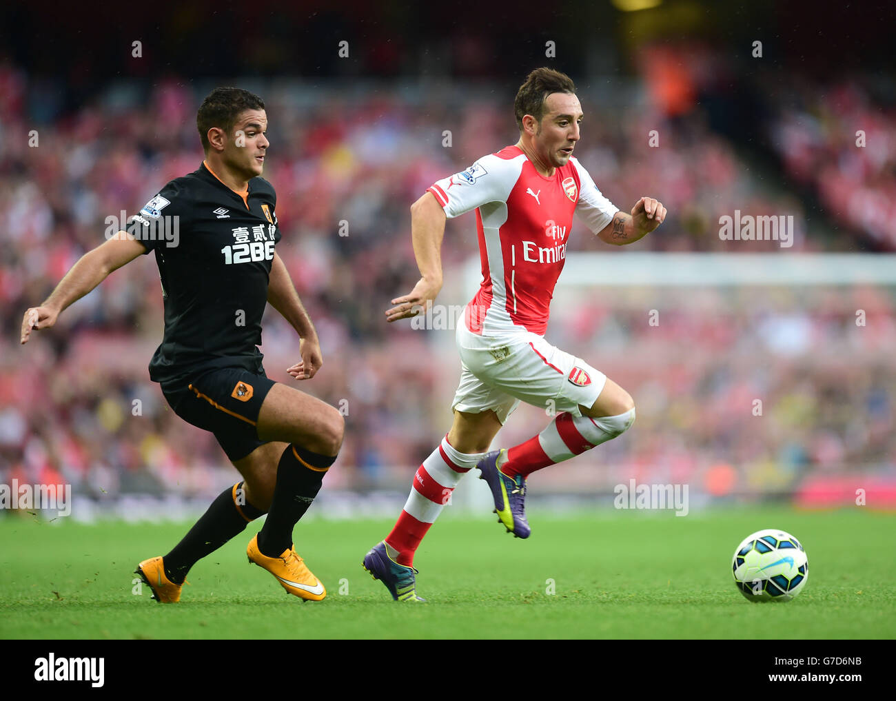 Hatem ben Arfa di Hull City (a sinistra) batte per la palla con i Santi Cazorla dell'Arsenal durante la partita della Barclays Premier League all'Emirates Stadium di Londra. Foto Stock