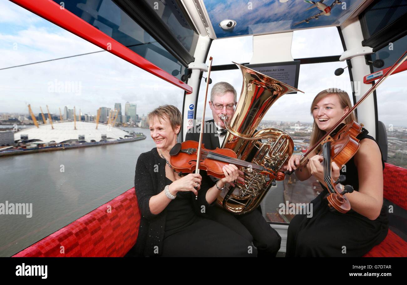 (Da sinistra a destra) Paula Martin, David Young e Hattie Gough della Salomon Orchestra che contribuiscono a celebrare la Stagione classica all'O2 con a&Ecirc; spettacolo a bordo della Emirates Air Line a Greenwich, a sud-est di Londra. Foto Stock