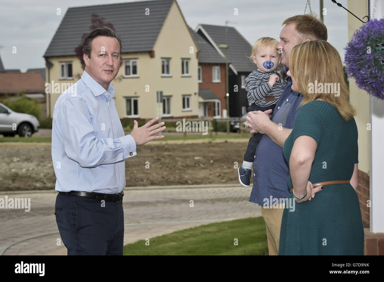 Il primo ministro David Cameron incontra Barry e Samantha McBeth e il loro vecchio Alfie di un anno durante una visita alla nuova proprietà immobiliare del Taylor Wimpy Great Western Park, Didcot, Oxfordshire, in vista dell'inizio della Conferenza del Partito conservatore. Foto Stock