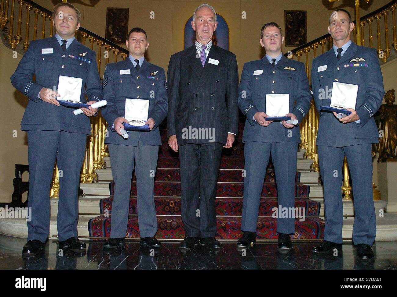 L'ammiraglio Sir Peter Abbott GBE KCB, Centre, il Vice Presidente della Royal Benevolent Society del pescatore e dei marinai naufragato si trova con l'equipaggio di Rescue 131, RAF Boulmer, al quale è stato assegnato il premio Edward and Maisie Lewis Award per un eccezionale salvataggio aereo/marittimo, il tenente del volo Andrew Doyle (co-pilota), all'estrema sinistra, Volo Sargeant Paul Mills (radar e operatore verricello), seconda a sinistra, tenente di volo Andrew Doyle (co-pilota), seconda a destra, e tenente di volo Dieter Booth (pilota) nella città di Londra. Nel dicembre 2003, Rescue 131 da RAF Boulmer ha salvato un crewman gravemente malato a bordo Foto Stock