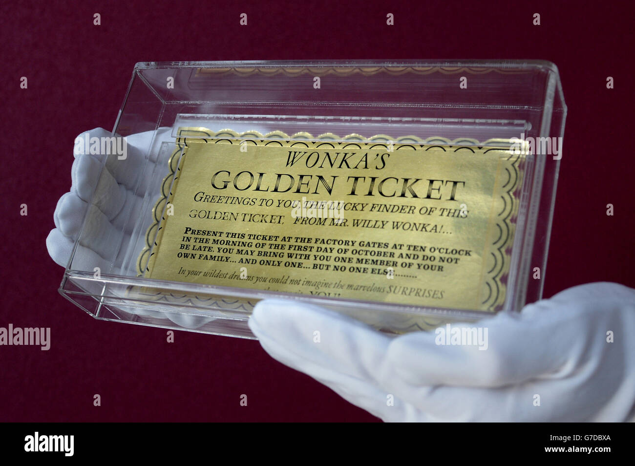 Un assistente alla mostra tiene il biglietto d'oro di Wonka del film Willy Wonka e della fabbrica di cioccolato (stimato a &Pound;15,000 - &Pound;20,000) mentre l'iconica mostra di memorabilia cinematografica di Hollywood apre a Vue Westfield, Londra. Foto Stock