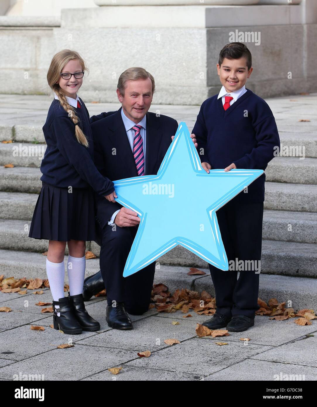 Taoiseach Enda Kenny, cui hanno aderito gli alunni Antonio Burlan e Leah Masterson della Gardiner Street School per celebrare il lancio del quarto anno del programma Blue Star, che oggi promuove una migliore comprensione dell'UE presso gli edifici governativi di Dublino. Foto Stock