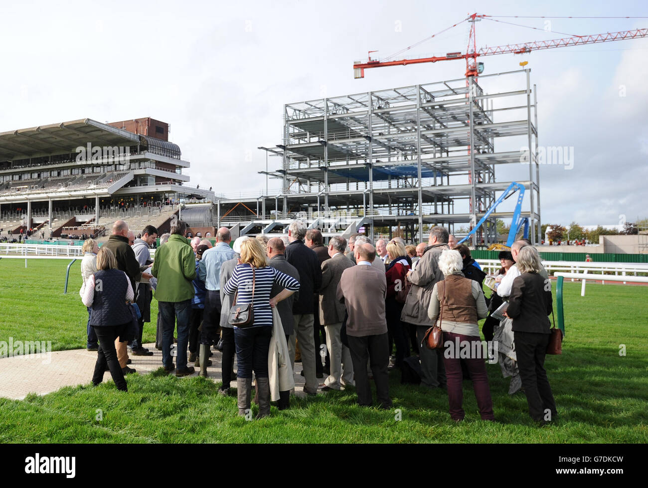 I Racegoers hanno un tour di fronte alla costruzione della nuova tribuna durante il primo giorno della riunione Showcase 2014 all'ippodromo di Cheltenham, Cheltenham. Foto Stock