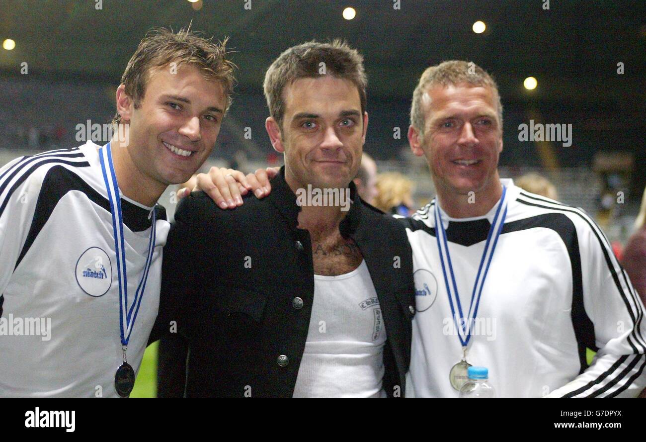 Da sinistra a destra; Jonathan Wilkes, Robbie Williams e Alec Stewart dopo la finale live "The Match" di Sky One ha giocato contro una Football Legends XI al St James' Park di Newcastle. Foto Stock