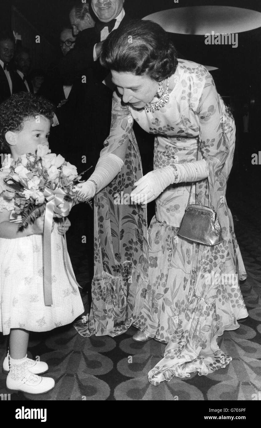 La regina Elisabetta II partecipa alla prima europea della carità del Champ. Ha chiesto a Lucia Isaacs di 3 anni 'è per me?', ma il bambino ha rifiutato di rinunciare al bouquet. Foto Stock