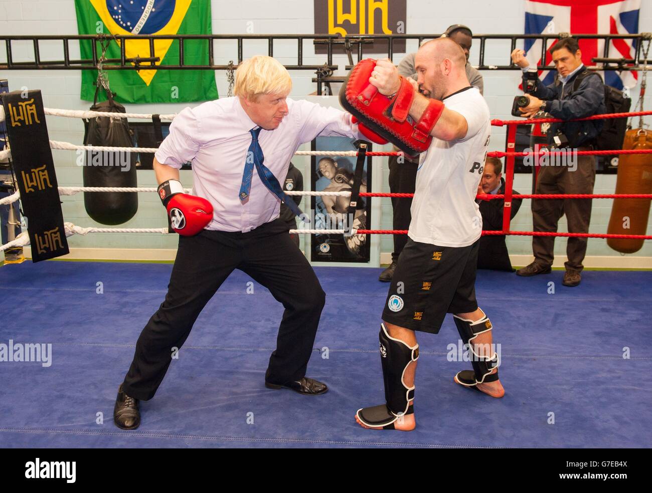 Il sindaco di Londra Boris Johnson partecipa a una sessione di pugilato durante una visita all'accademia di pugilato lotta per la pace, che lavora con i giovani a rischio di criminalità e violenza a North Woolwich, a est di Londra. Foto Stock