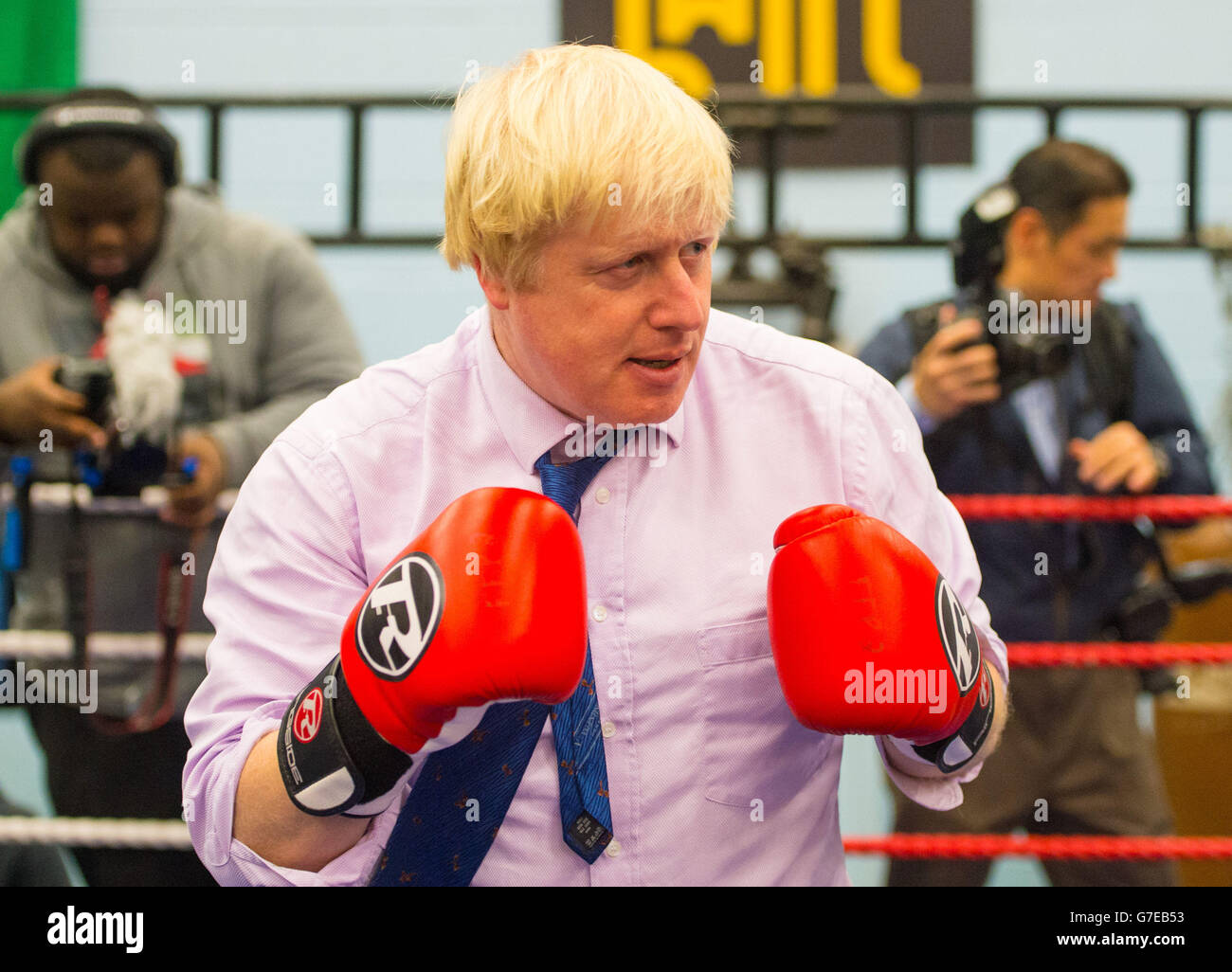 Il sindaco di Londra Boris Johnson partecipa a una sessione di pugilato durante una visita all'accademia di pugilato lotta per la pace, che lavora con i giovani a rischio di criminalità e violenza a North Woolwich, a est di Londra. Foto Stock