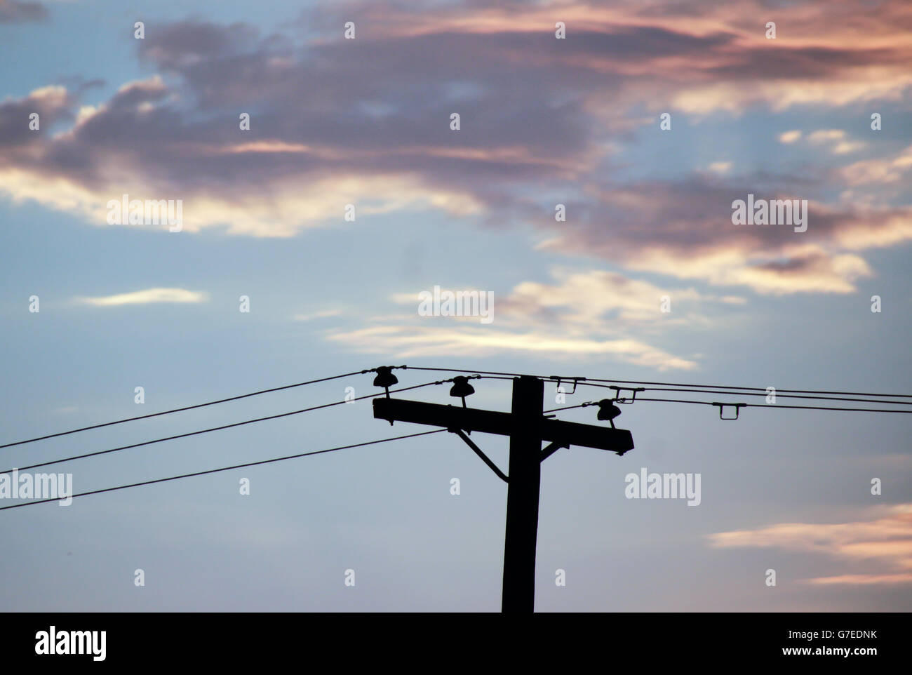 Fotografia di un palo elettrico e un cielo nuvoloso al tramonto Foto Stock