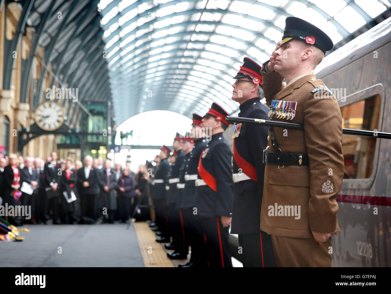 Il personale di servizio militare servente e veterano esegue una Guardia d'onore durante un evento di ricordo con la locomotiva di Classe 91 della East Coast, specialmente in livrea, 'for the Fallen' (numero 91111) alla stazione di King's Cross a Londra. Foto Stock