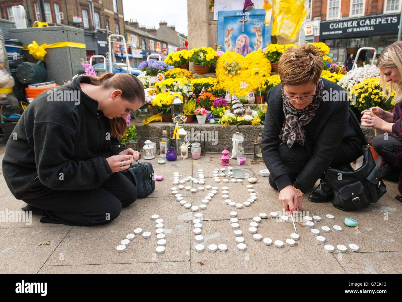 I Mourners illuminano le candele in memoria dell'adolescente assassinato Alice Gross alla Torre dell'Orologio di Hanwell mentre il traffico si fermò e la gente del posto uscì a pagare i loro omaggi ad Hanwell, Londra occidentale, mentre il corteo funebre passò attraverso con una scorta di polizia. Foto Stock