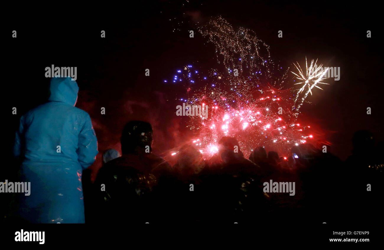 La gente guarda i fuochi d'artificio a Shell Island, vicino a Barmouth durante il vento e la pioggia. Foto Stock