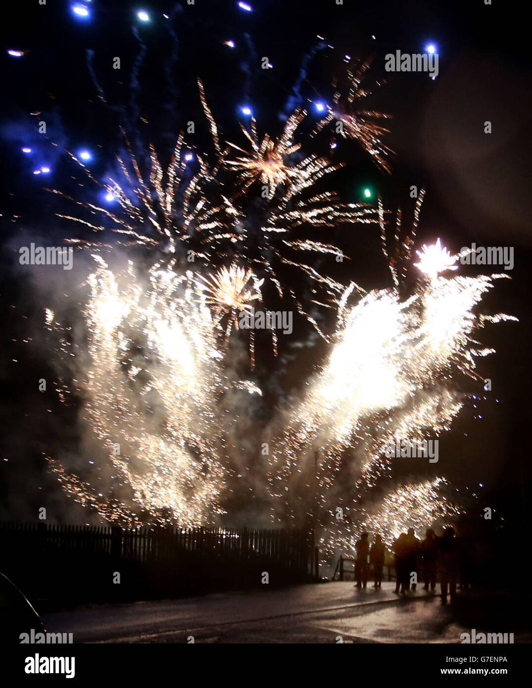 La gente guarda i fuochi d'artificio a Shell Island, vicino a Barmouth durante il vento e la pioggia. Foto Stock