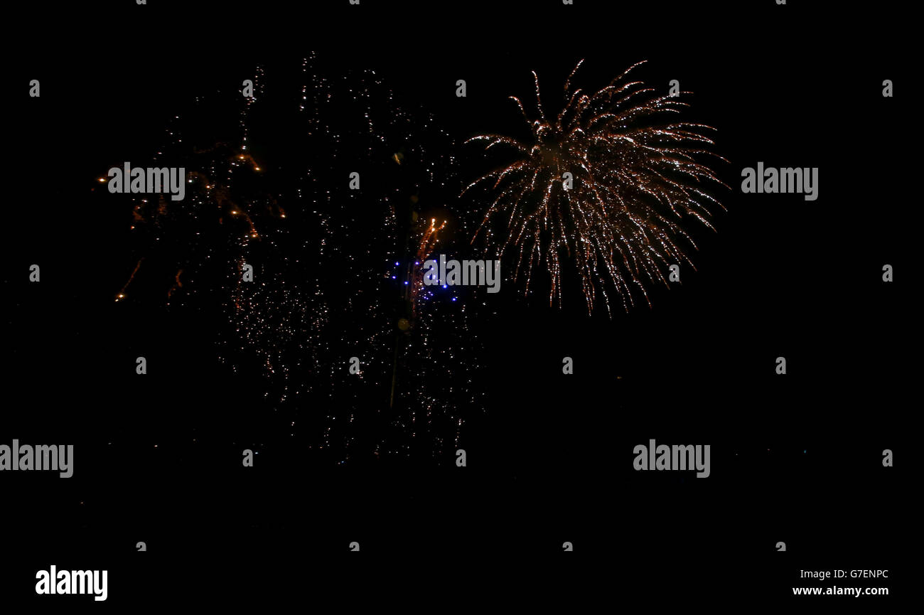 La gente guarda i fuochi d'artificio a Shell Island, vicino a Barmouth durante il vento e la pioggia. Foto Stock
