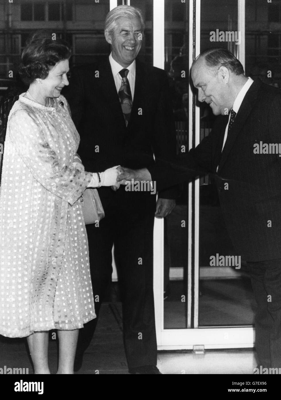 La regina Elisabetta II stringe le mani con Robert Muldoon, primo ministro della Nuova Zelanda, seguito dall'Alto commissario Leslie Gandar. Un ricevimento si è tenuto presso la New Zealand House di Haymarket per celebrare l'arrivo a Londra della prima spedizione refrigerata di agnello neozelandese 100 anni fa. Foto Stock