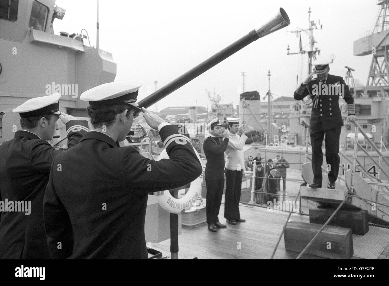 Scambio di saluti come il Duca di Edimburgo è pied a bordo del minehunter HMS Bronington da 360 tonnellate per essere accolto dal capitano, il tenente Principe Carlo (primo piano). Il Duca, in Ammiraglio dell'uniforme della flotta, stava facendo una visita informale alla nave - il primo comando del Principe - alla base navale di Rosyth. Foto Stock