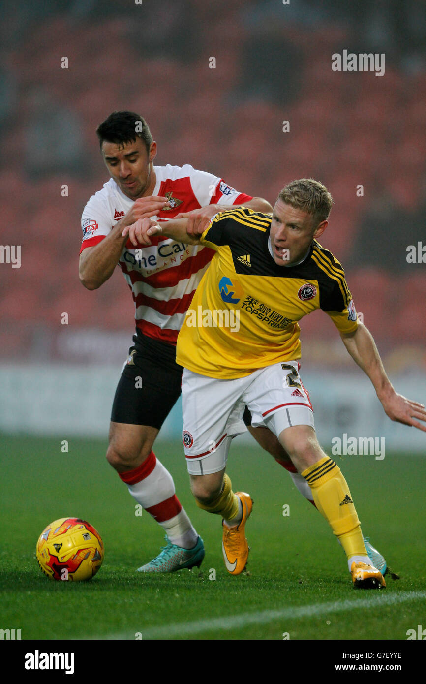 Craig Alcock di Sheffield United (a destra) e Enda Stevens di Doncaster combattono per la palla durante la partita Sky Bet League One allo stadio Keepmoat di Doncaster. Foto Stock