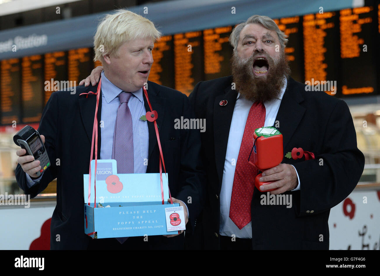 Il sindaco di Londra Boris Johnson (a sinistra) e l'attore Brian Beato vendono papaveri nella stazione di Liverpool Street nel centro di Londra. Foto Stock