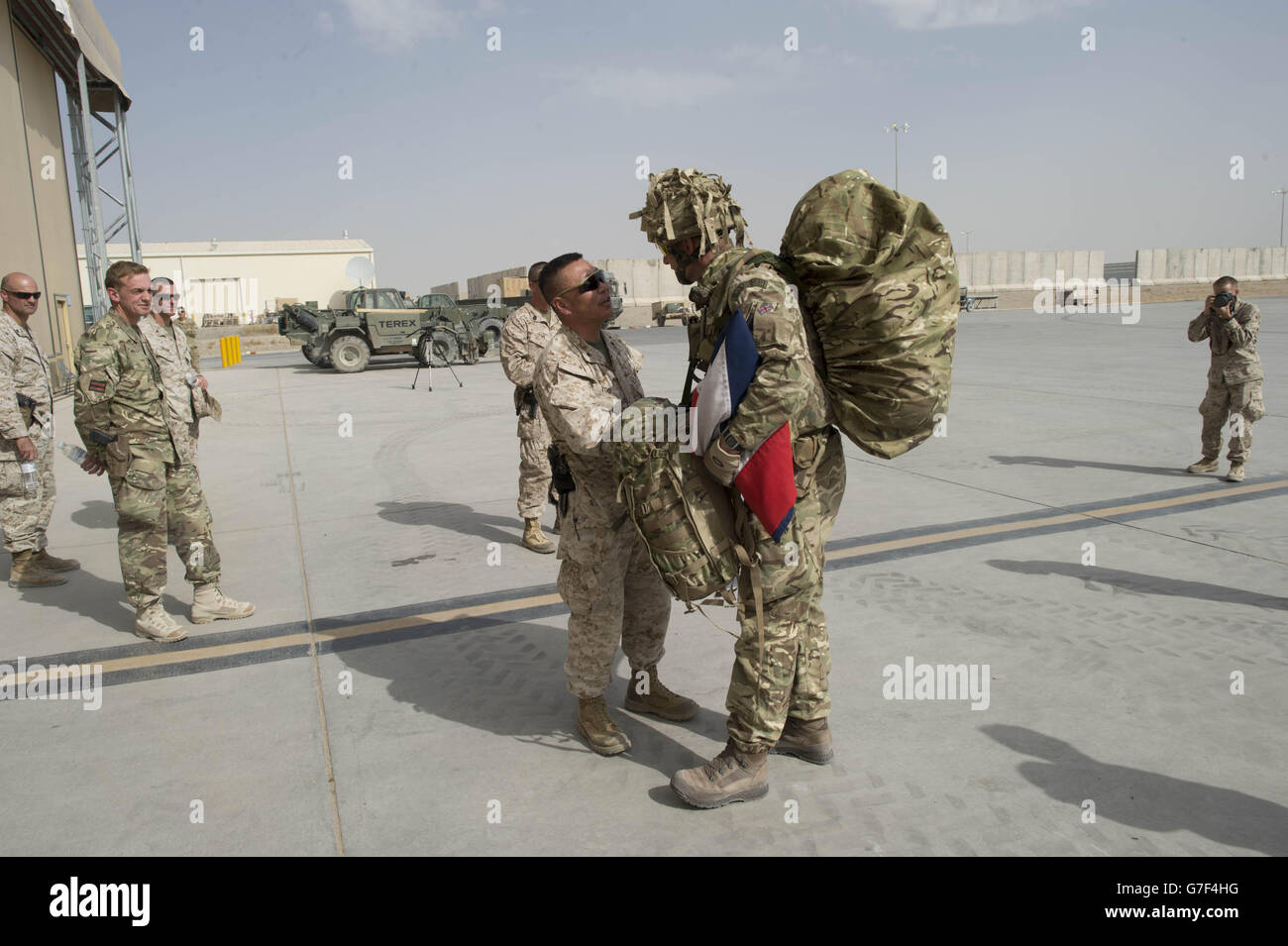 Wing Commander Matt Radnall, ufficiale che comanda 7 Force Protection Wing, scuote le mani con il generale del brigadiere Dan Yoo all'arrivo sicuro a Kandahar, Ancora portando con sé la sua bandiera dell'Unione piegata con attenzione mentre l'ultimo elicottero britannico Chinook atterra dopo che il Regno Unito e le forze della Coalizione completarono il loro ritiro tattico lasciando il Bastione del campo e consegnandolo all'esercito nazionale afgano. Foto Stock