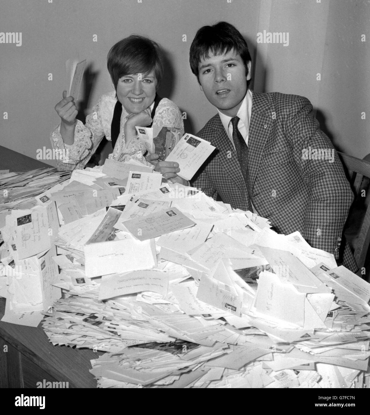 Di fronte a una montagna di cartoline sono i cantanti pop Cilla Black e Cliff Richard presso l'ufficio televisivo della BBC a Shepherd's Bush, Londra, che hanno contribuito a contare i voti per la canzone britannica per l'Europa. Foto Stock