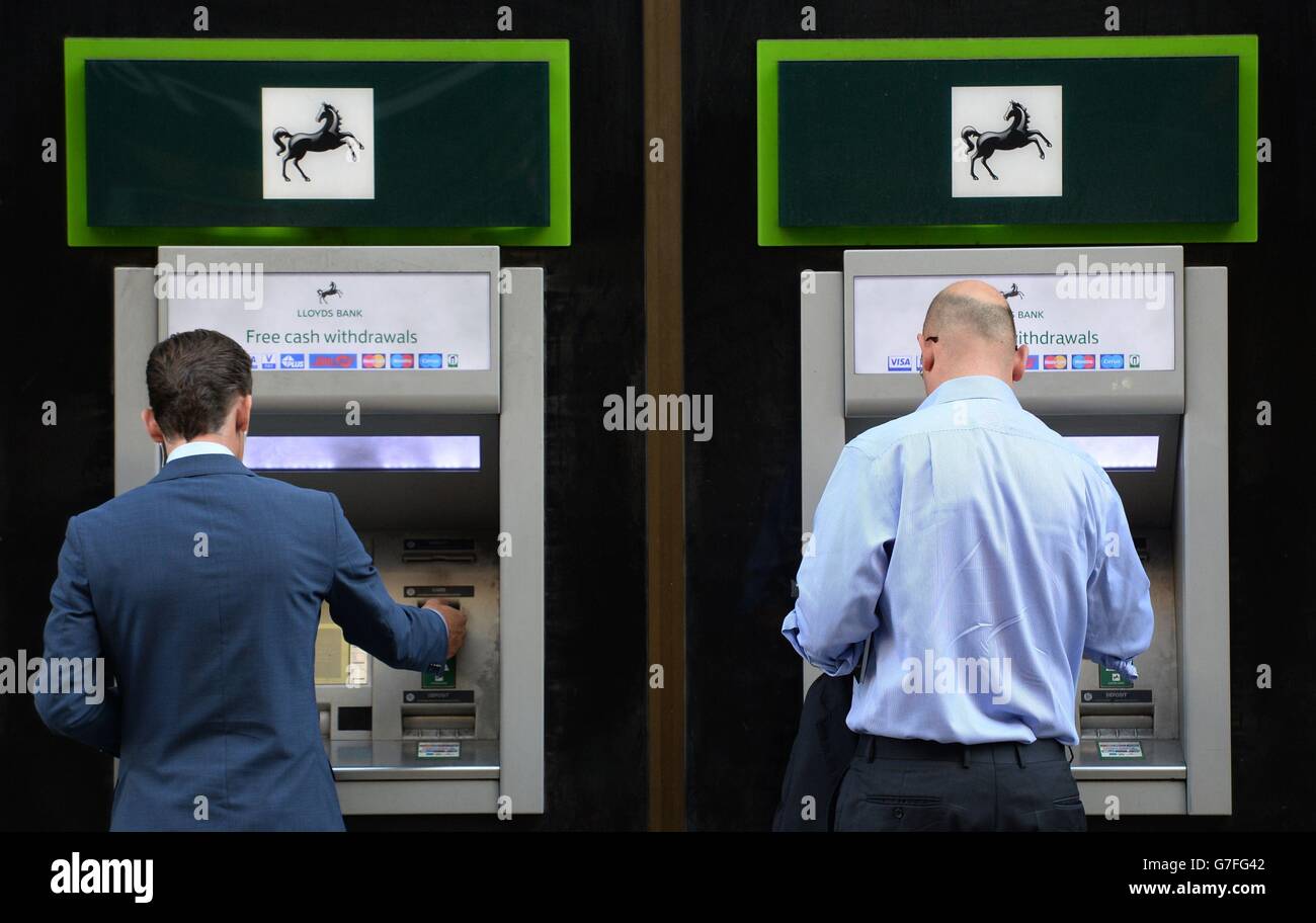 I membri della banca pubblica usano le macchine di cassa in una filiale della Lloyds Bank nella città di Londra, dopo che il gruppo bancario sostenuto dallo stato ha annunciato che è necessario tagliare 9,000 posti di lavoro nei prossimi tre anni come parte di piani che vedranno la chiusura netta di 150 filiali. Foto Stock