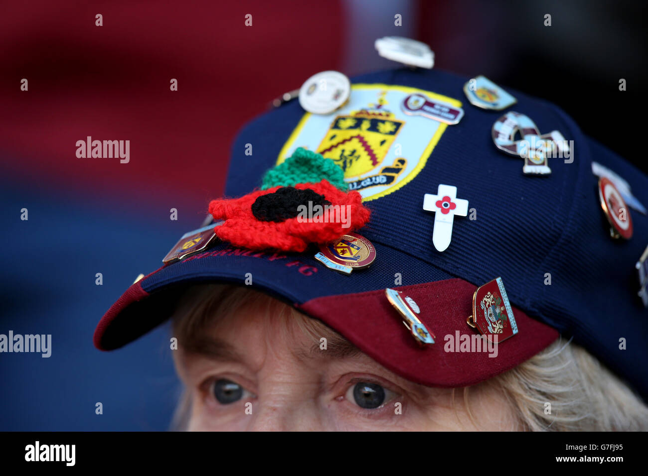 Un ventilatore di Burnley indossa un cappello che porta un papavero e.  distintivi del club Foto stock - Alamy