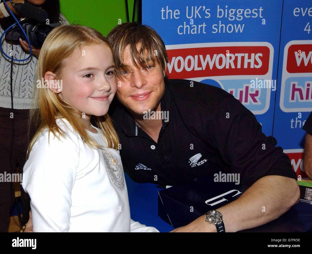 Duncan James della boy band Blue, con il fan di otto anni Charlotte Head, durante l'apparizione presso il negozio Woolworths Big W a Small Heath, Birmingham, per promuovere il loro album "Best of Blue". Foto Stock