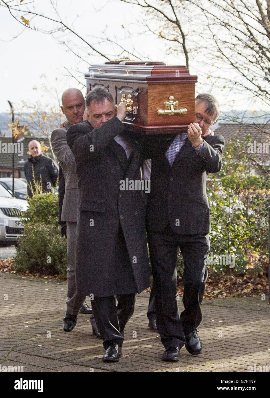 Il funerale della vittima scomparsa Brendan Megraw è portato alla chiesa di St Oliver Plunkett a Belfast dai suoi fratelli Kieran (seconda a sinistra) e Sean (a destra), dopo che i suoi resti sono stati trovati in una palude in Co Meath il mese scorso, dopo una lunga ricerca dopo 36 anni. Foto Stock