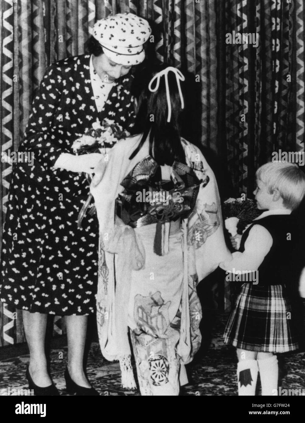 La regina Elisabetta II riceve fiori all'apertura della Nippon Electric Company a Livingston, da Rie Manube di otto anni e Scot Martin Gold di due anni. Foto Stock